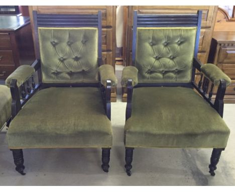 A pair of Victorian armchairs with turned legs, ceramic casters, spindle arms and green velvet upholstery.