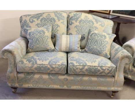 A reproduction Victorian 2 seater sofa in cream & blue damask upholstery with wooden & brass legs, in excellent condition.