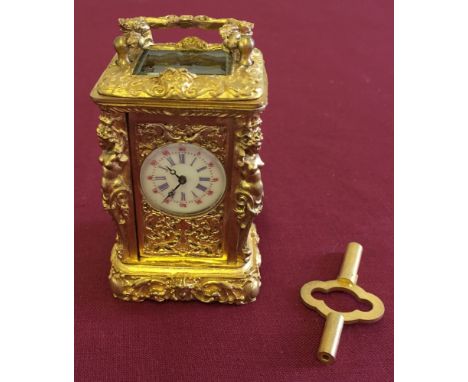 A Miniature gilt metal carriage clock with enamel dial in working order, 7cm tall.
