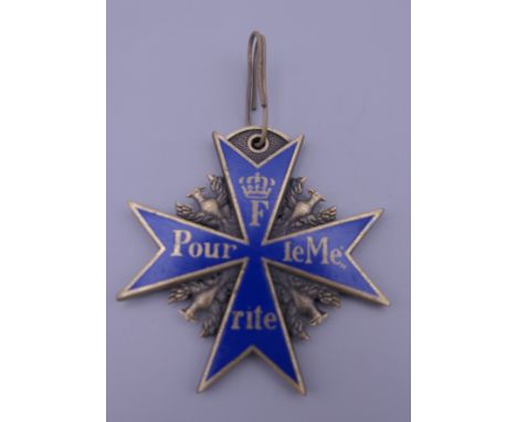 A cross form medal with enamel decoration. 5.5 cm high. 