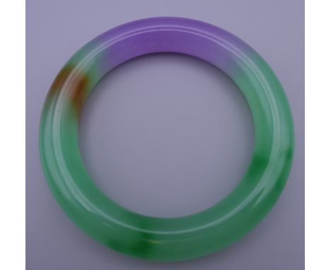 A multi-coloured jade bangle. 8.5 cm outer diameter, 6 cm inner diameter.