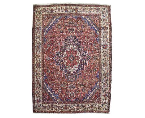 the rust red field with indigo, ivory and red medallion, indigo and pink spandrels, within ivory palmette and vine border590c