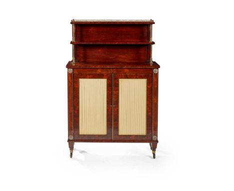 the upper section with two shelves above a base with yellow pleated silk lined doors, on tapered legs with brass castors, sta