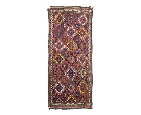 the red field with allover hooked medallion pattern, within narrow ivory ram's head border310cm x 160cm