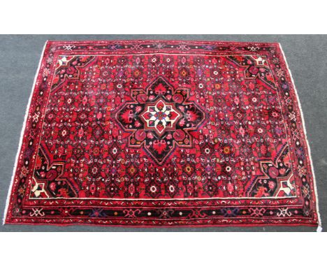 A 20th century Hamadah rug, woven with a central eight point medallion and conforming spandrels on a madder ground. 220 x 152