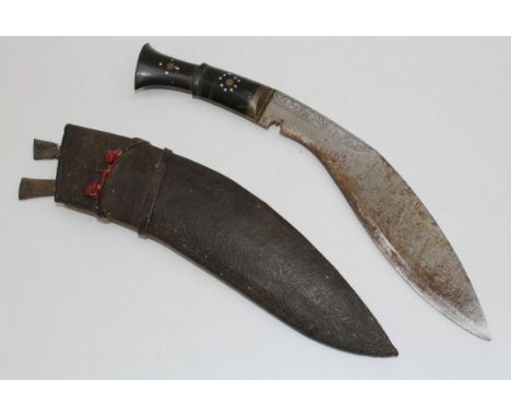 A mid 0th century Kukri, with side knives, in a stitched leather scabbard. Total length 43cm