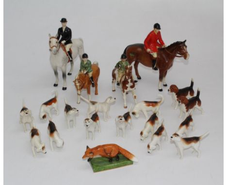 A Beswick hunting group. Comprising huntsman on chestnut, lady on a grey, boy on palomino, girl on skewbald, fifteen hounds a