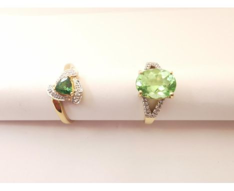 Two 20th century 18 carat yellow gold gem-set rings: a flanked solitaire dress ring set with a green stone and a triangular d