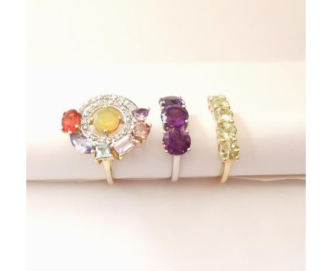 Three 20th century 10 carat gold gem-set rings: an abstract design ring set with Ethiopian fire opal, fire opal, Tanzanite an