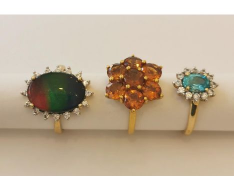 Three 20th century 10 carat white gold gem-set rings: a Citrine floral cluster ring, an ammolite oval cabochon triplet cluste