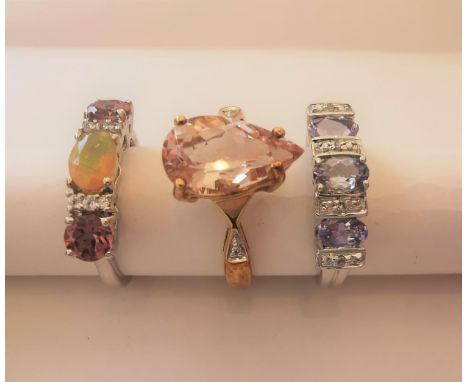 Three 20th century 10 carat gold gem-set rings: a drop shape flanked solitaire ring set with a drop shape mixed cut Morganite