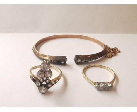 A collection of yellow metal and 9 carat gold jewellery. A three stone diamond ring, a rose gold clip bracelet with safety ch