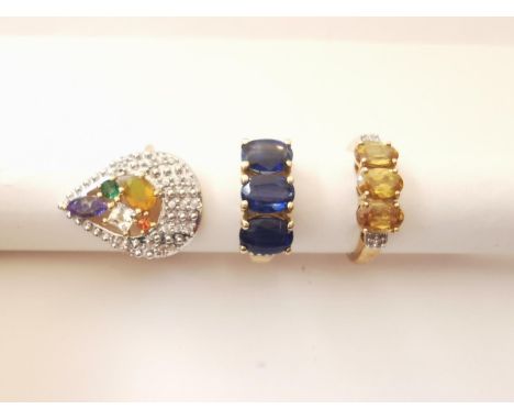 Three 20th century 10 carat gold gem-set rings: a three stone sapphire and diamond ring, a yellow stone and diamond three sto