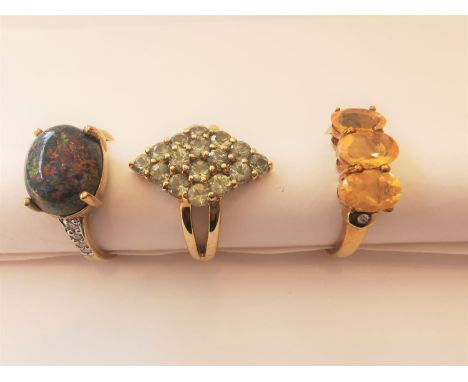 Three 20th century 9 carat yellow gold gem-set rings: a sugar treated black opal and diamond flanked solitaire ring, a three 