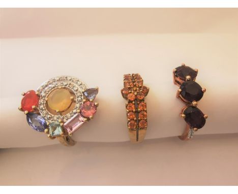 Three 20th century 10 carat white gold gem-set rings: a Citrine floral design dress ring, an abstract cluster ring set with f