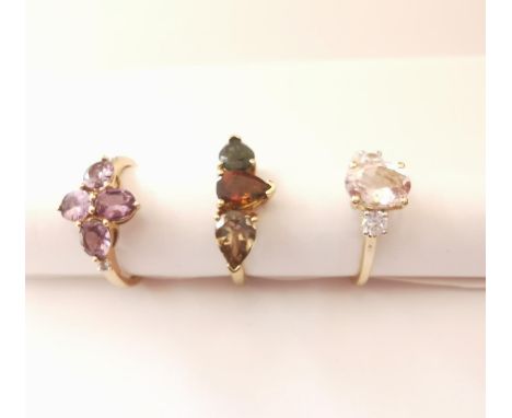 Three 20th century 10 carat gold gem-set rings: a flanked solitaire Morganite ring, a three stone prasiolite and tourmaline r