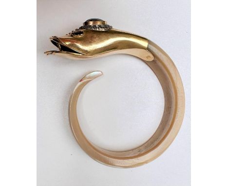 A 15 carat yellow gold and carved shell snake bangle. The gold head has an open mouth with tongue protruding. In the middle o
