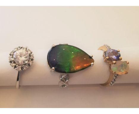 Three 20th century 10 carat yellow gold gem-set rings: a drop shape ammolite triplet cabochon dress ring, a cubic zirconia cl