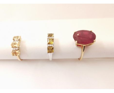 Three 20th century 10 carat gold gem-set rings: a solitaire ring set with an oval mixed cut ruby with an approximate carat we