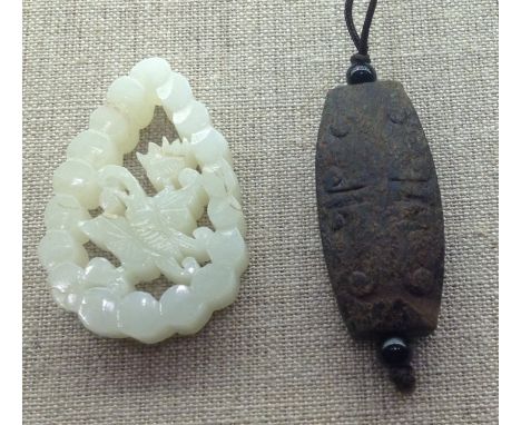 A CHINESE PALE GREEN JADE PENDANT Carved with a central butterfly and a flower enclosed by a border, along with a carved  hea