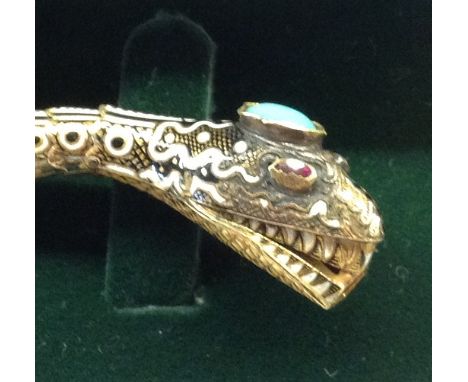 A 19TH CENTURY YELLOW METAL SNAKE FORM BRACELET Inlaid with cabochon cut turquoise to head, with ruby eyes and black and whit