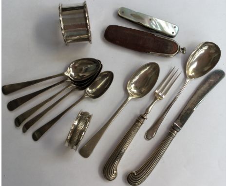 A collection of silver spoons, napkin rings, a mother of pearl pen/multitool penknife (s/s blades), also Georgian and filled 