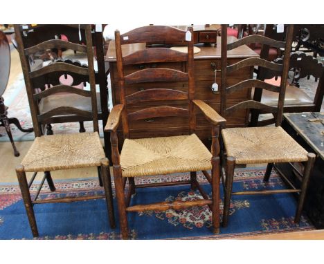 A 19th Century ash and elm ladder back armchair, together with a pair of ladder back side chairs, all with rush seats (3)