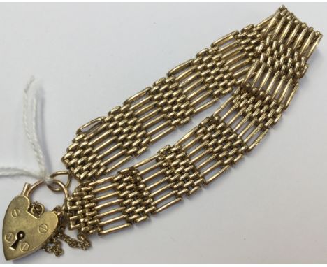 A 9ct gold gate bracelet with padlock fastener, approx width 15mm, weight 26.1 grams approx 