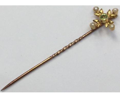 A pearl and peridot set stick pin.
