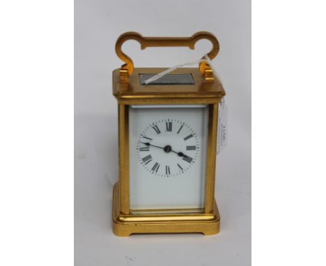 A first quarter 20th Century carriage clock, possibly English gilt brass with glazed panels, Roman numerals 