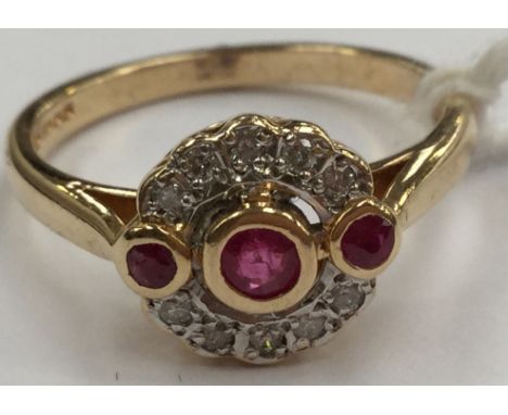 An Art Deco style ruby and diamond ring, set with three rubies with a halo of diamonds, 18ct gold, size O½, total gross weigh