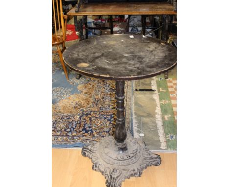 A Victorian circular topped pub table, with a cast iron base, together with a pair of cast iron black painted and mahogany to