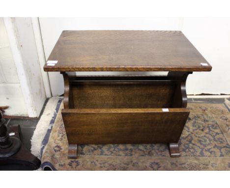 An oak joined coffee table, the solid top raised on turned supports, together with an oak magazine rack (2)