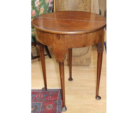 A George II style mahogany fold-over tea table, raised on turned supports with pad feet