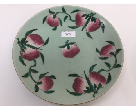 A 19th Century Chinese provincial circular celadon ground dish, enamel decorated with fruit, blue seal mark, diameter 26cm