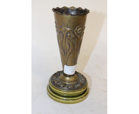 An Arts & Crafts repousse brass vase in the Art Nouveau style, decorated with stylised daisies, on a ceramic base, 18cm high