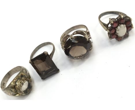 A sterling silver dress ring with a large faceted smoky quartz stone, a sterling silver ring with garnet and opal (flower hea