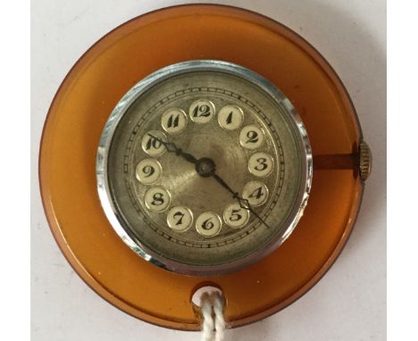 An Art Deco chrome and lucite pendant watch, amber plastic with engine turned dial, 4cm diameter