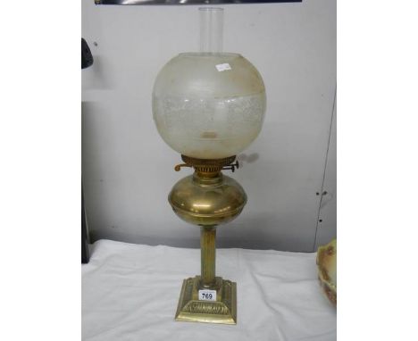 A brass oil lamp on cast base with reeded column, brass font  complete with burner, chimney and etched glass shade.