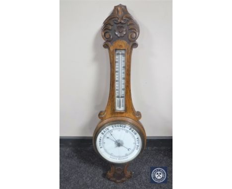 A carved oak aneroid barometer (glass cracked)