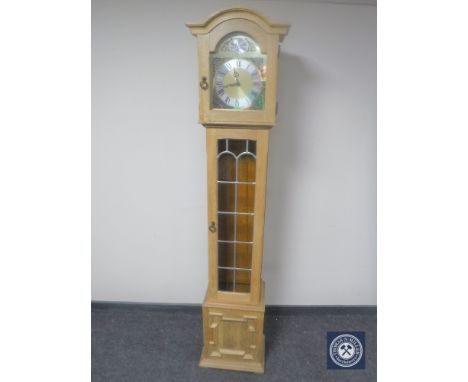 A blond oak Tempus Fugit longcase clock with pendulum and weights 