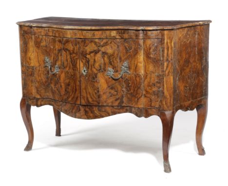 AN ITALIAN WALNUT COMMODE 18TH CENTURY AND LATER the shaped quarter veneered top above a pair of hinged doors, enclosing a di