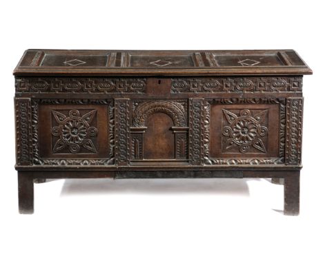 AN OAK COFFER 17TH CENTURY AND LATER with a triple panelled lid above a strapwork frieze, with a central arched panel flanked