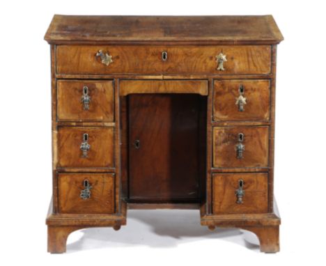 A WALNUT KNEEHOLE DESK EARLY 18TH CENTURY AND LATER with feather banding, the crossbanded rosewood top above an arrangement o