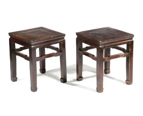 A PAIR OF CHINESE STAINED ELM LOW STANDS 19TH CENTURY each with a panelled top on scroll feet (2) 50.3cm high, 39.2cm wide, 3
