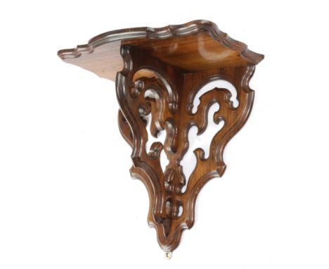 A VICTORIAN ROSEWOOD WALL BRACKET MID-19TH CENTURY the serpentine shelf on a wall plate and bracket with pierced, scrolling d