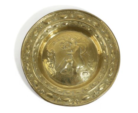 A NUREMBERG BRASS ALMS DISH PROBABLY 16TH / 17TH CENTURY decorated in shallow relief with King David playing the harp, inside