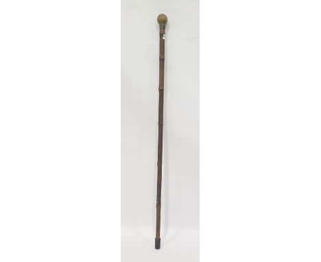 A rhino horn mounted walking stick, the ball-shaped horn handle above a metal collar and a bamboo walking cane, 88.5 cm longC