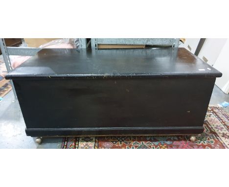 Black stained trunk on plinth base raised on casters