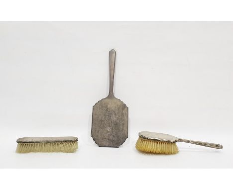 Silver-backed dressing table set, engine-turned, three pieces viz:- hand mirror and two various brushes